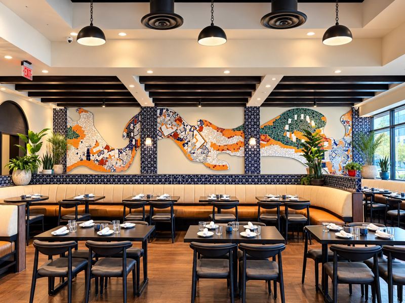 Gaudí style trencadís mosaic of broken tile and china flowing along the dining room wall of Bulla Gastrobar in Aventura, Miami, Florida, by Apperlo Art