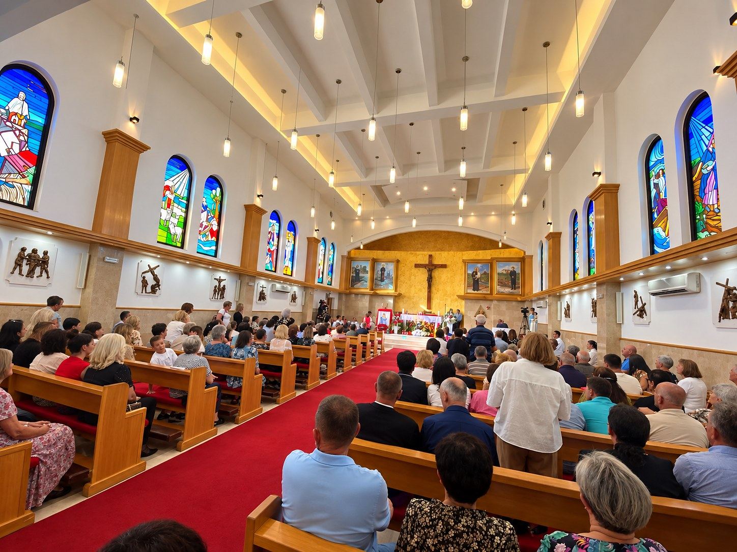 The parish gathered for Mass in the Church of the Sacred Heart in Čeljevo, beneath the stained glass windows along both walls