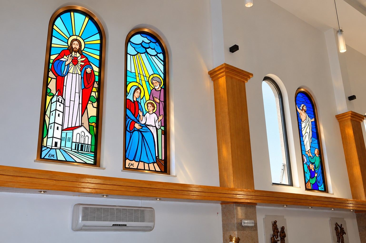 Pairs of arched stained glass windows above the pews of the Church of the Sacred Heart in Čeljevo