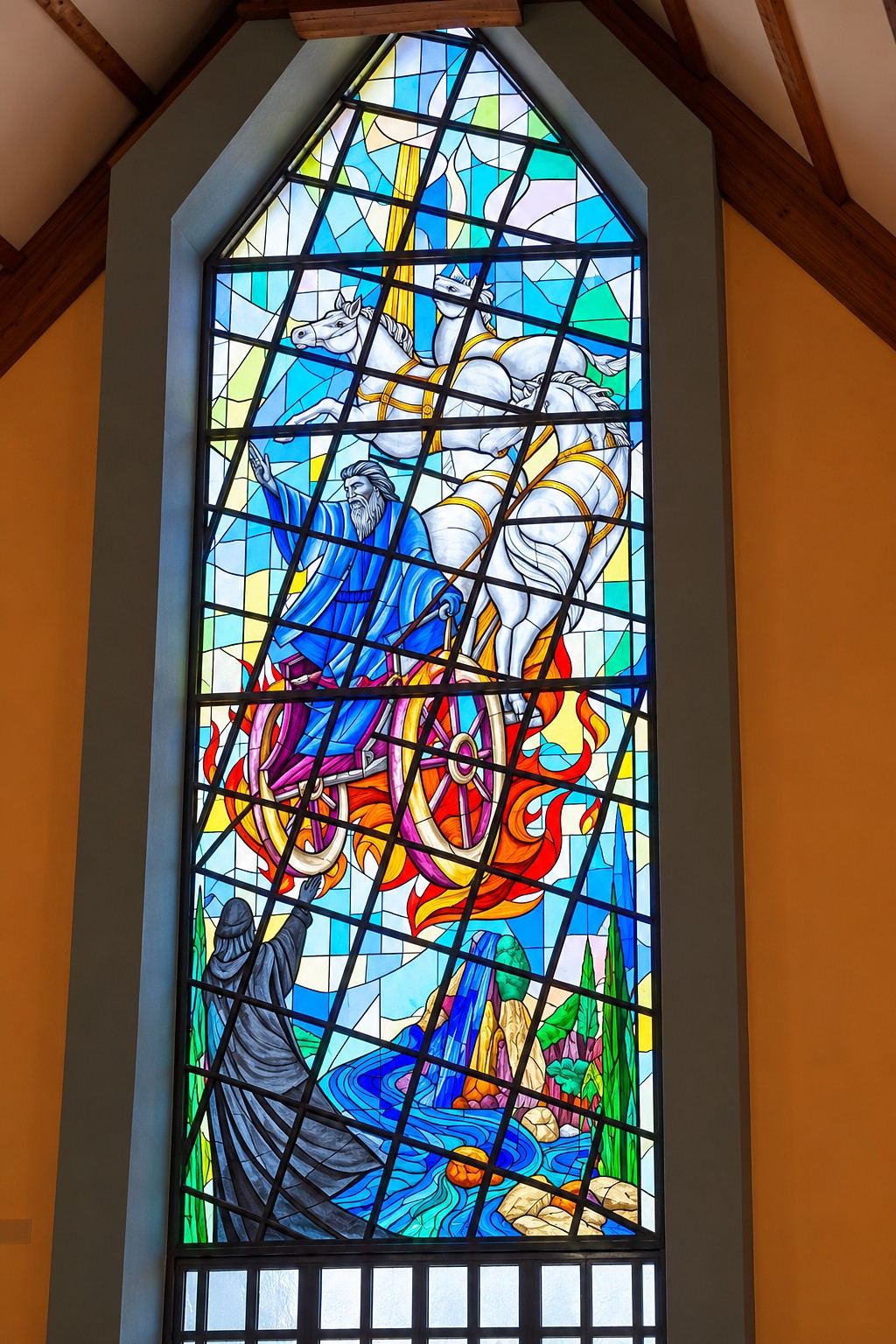 The tall stained glass window of the prophet Elijah taken up in a fiery chariot, designed by Stevan Stanisic, in the Church of Mary, Mother of the Church in Garevac, Bosnia and Herzegovina