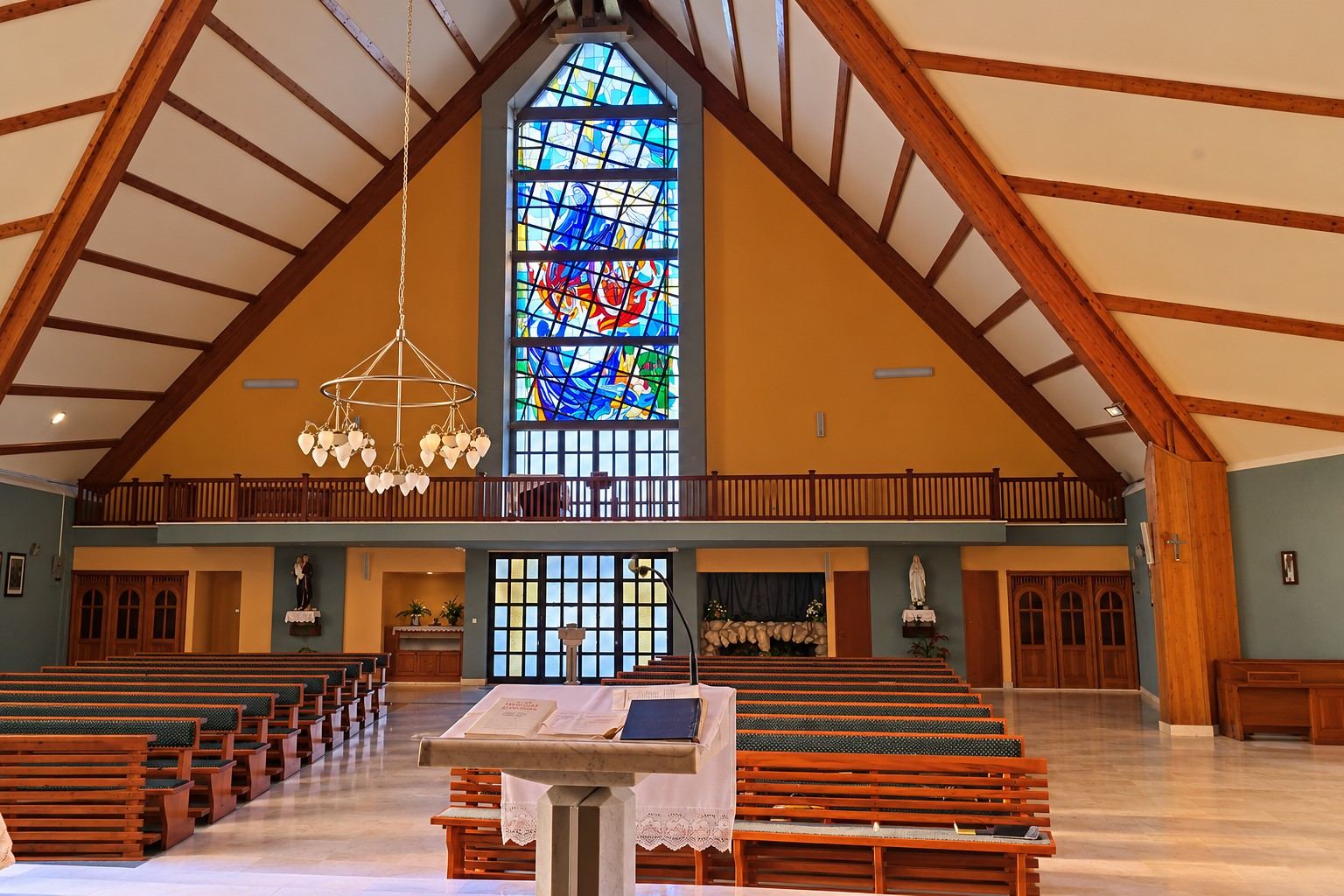 The interior of the Church of Mary, Mother of the Church in Garevac, with the stained glass window of Elijah above the choir loft