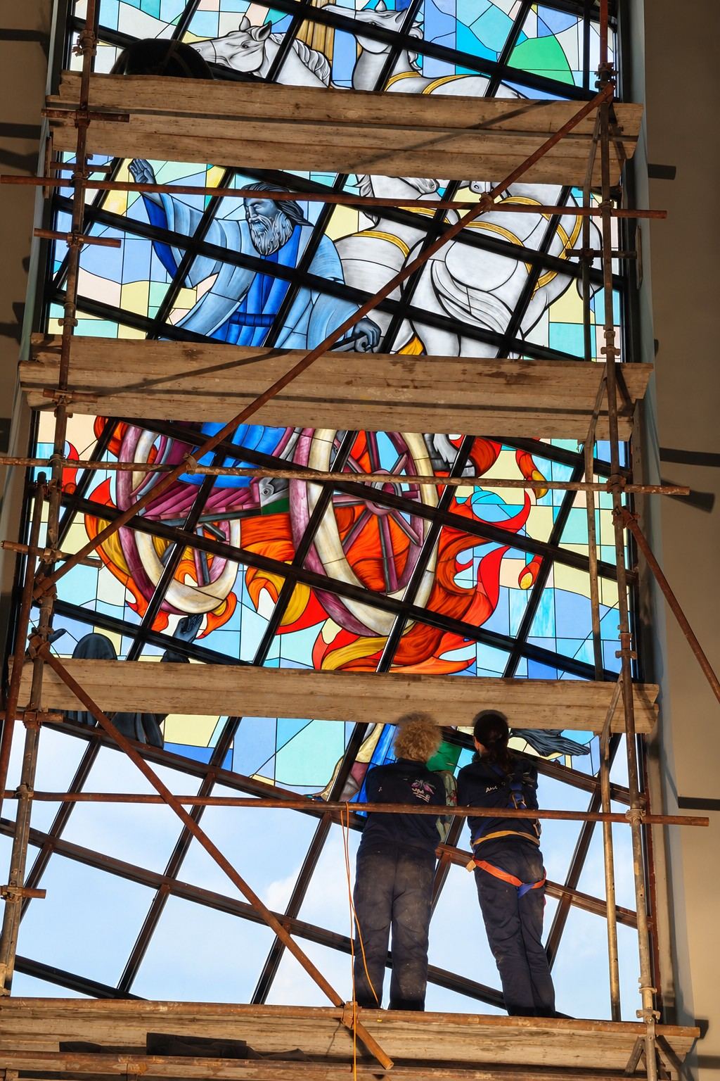 Installing the stained glass window of Elijah from a wooden scaffold in the church in Garevac