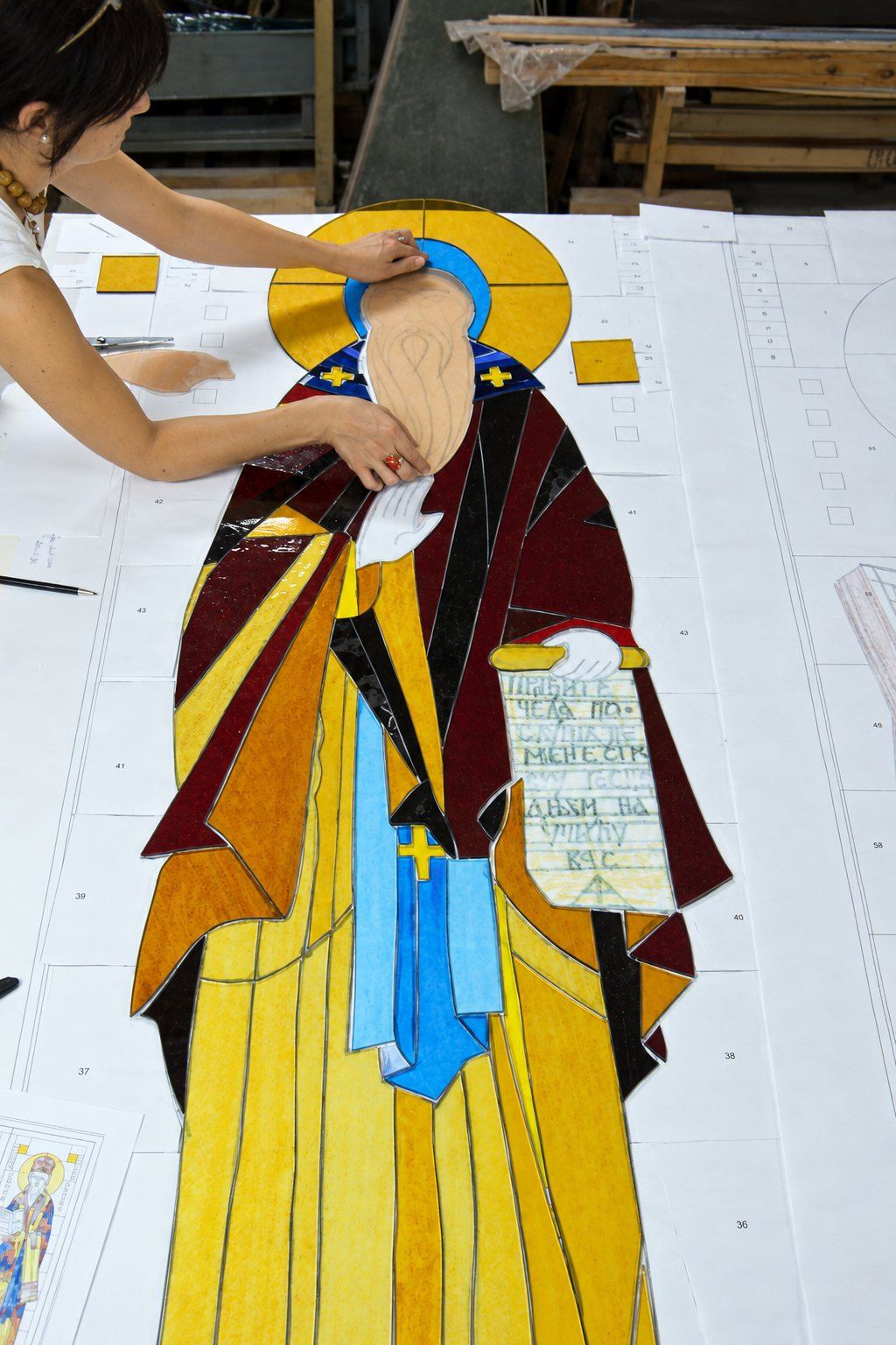 Mila Apperlo laying out the cut glass of Saint Simeon on the full size drawing in the studio, Sombor