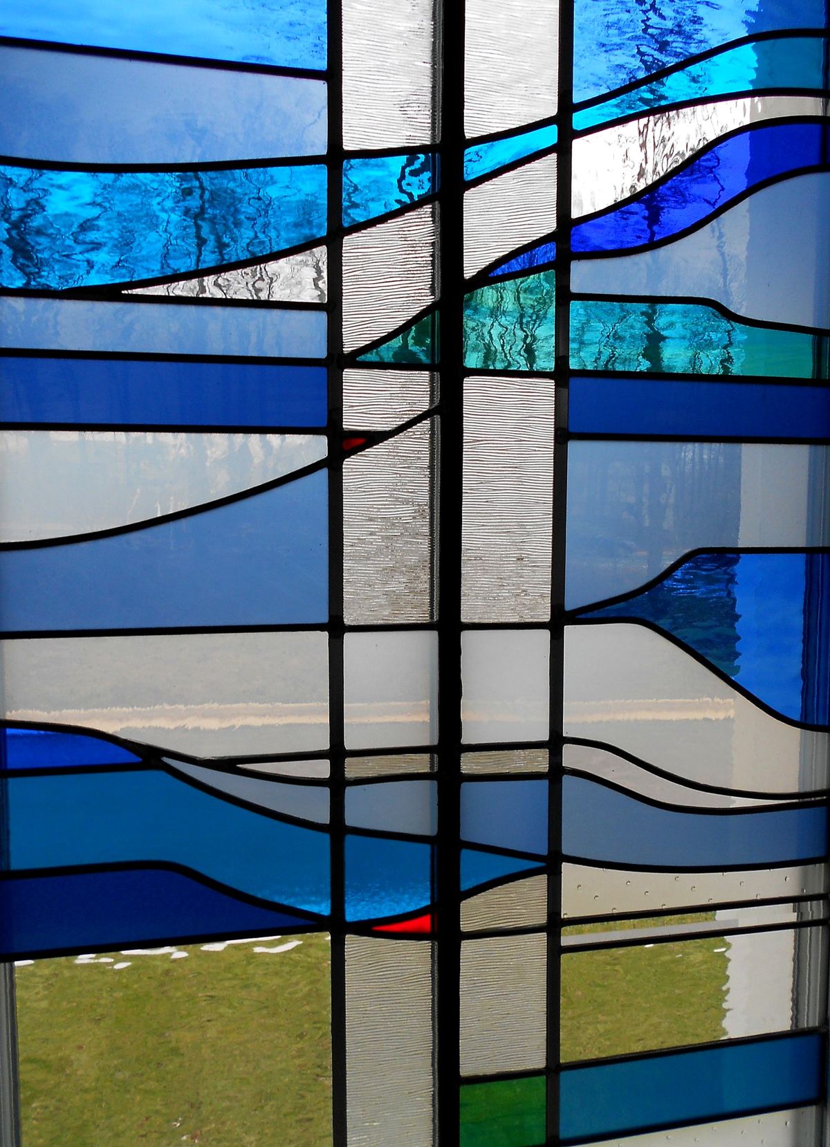 Close view of blue, turquoise and clear textured glass in a stained glass window at Heritage Fellowship Church, Reston, Virginia
