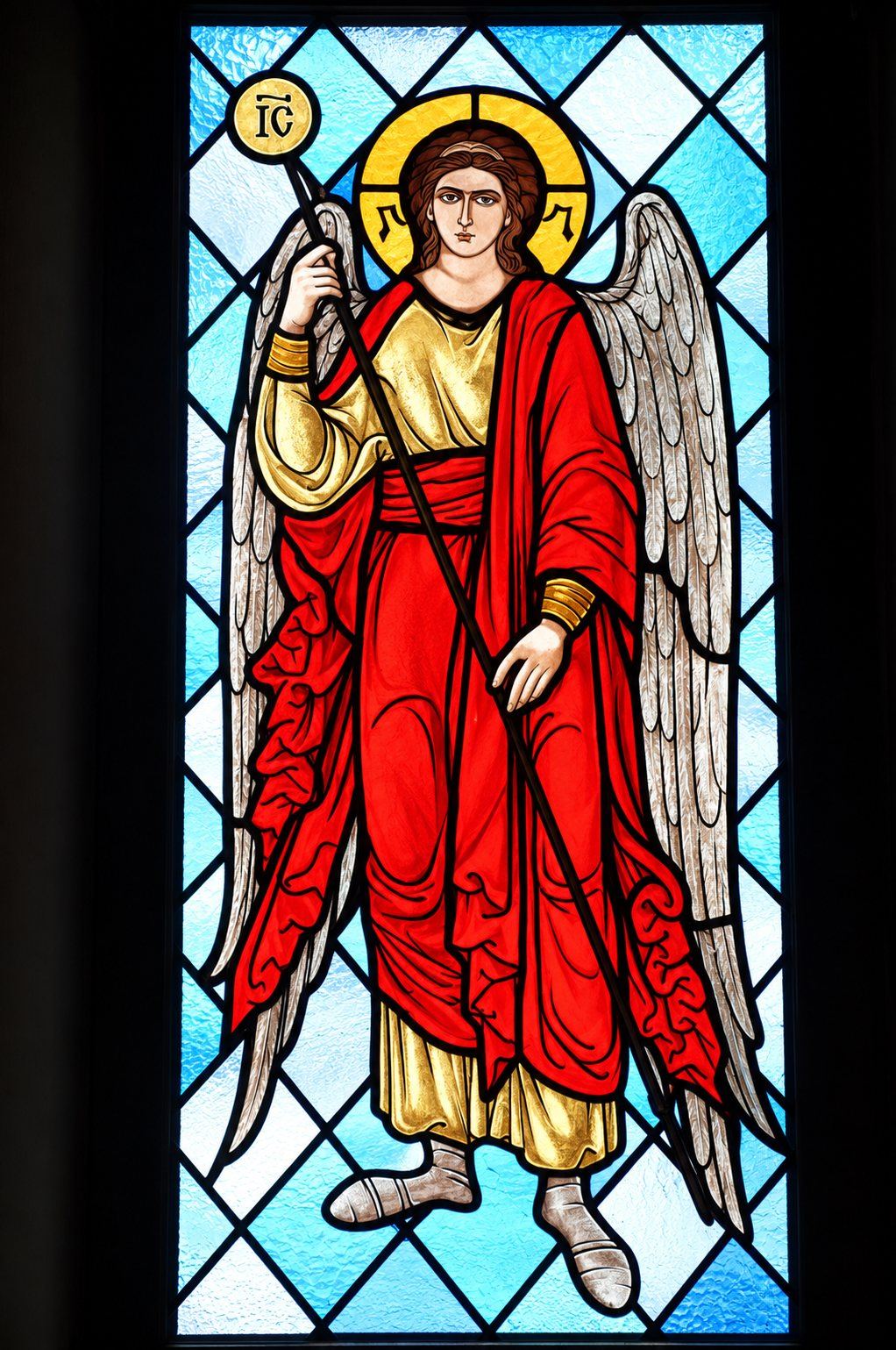 Stained glass window of an angel in a red and gold robe with a staff, Greek Catholic church in Mikluševci