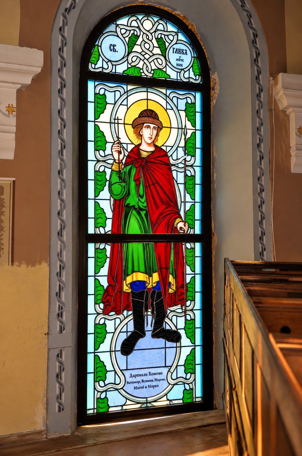 Stained glass window of Saint Gleb the martyr in a green tunic and red cloak, Greek Catholic church in Mikluševci