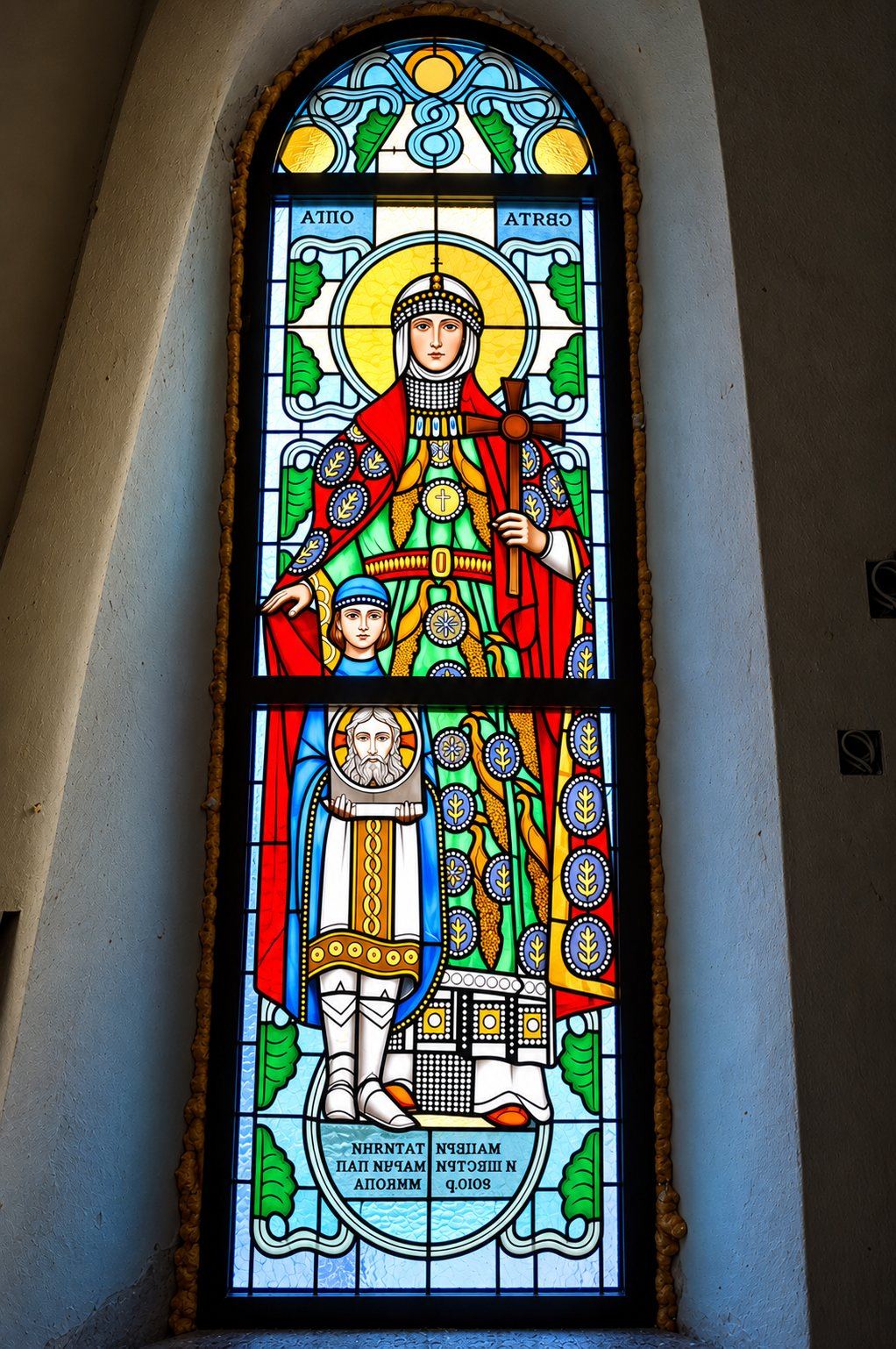 Stained glass window of Saint Olga with a crown, a cross and a red and green robe, Greek Catholic church in Mikluševci