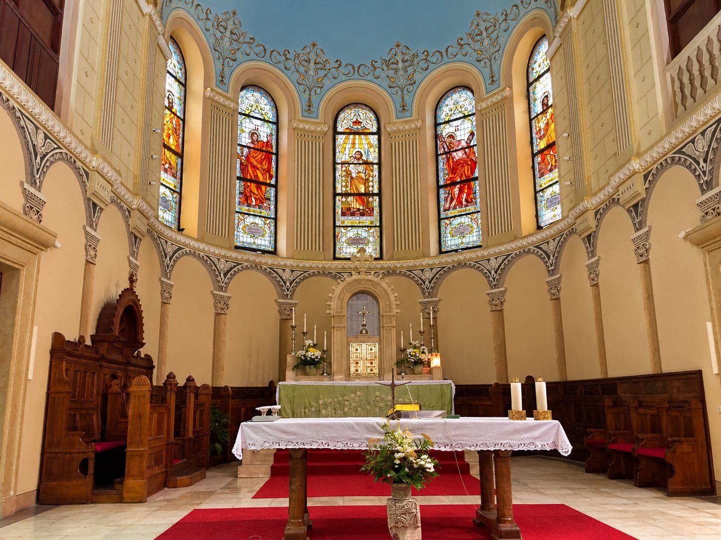 The sanctuary of the Church of Saint Joseph in Sarajevo with the altar and the stained glass windows of the apse