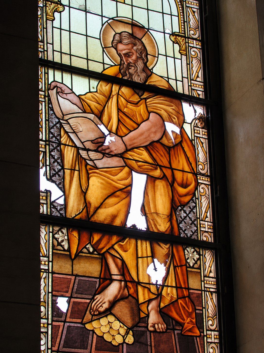 War damaged stained glass window of Saint Matthew with missing pieces, Saint Joseph, Sarajevo
