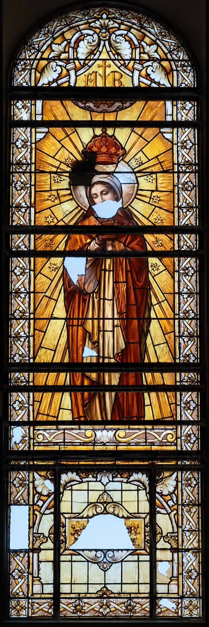 Tall war damaged stained glass window with broken panels, Saint Joseph, Sarajevo