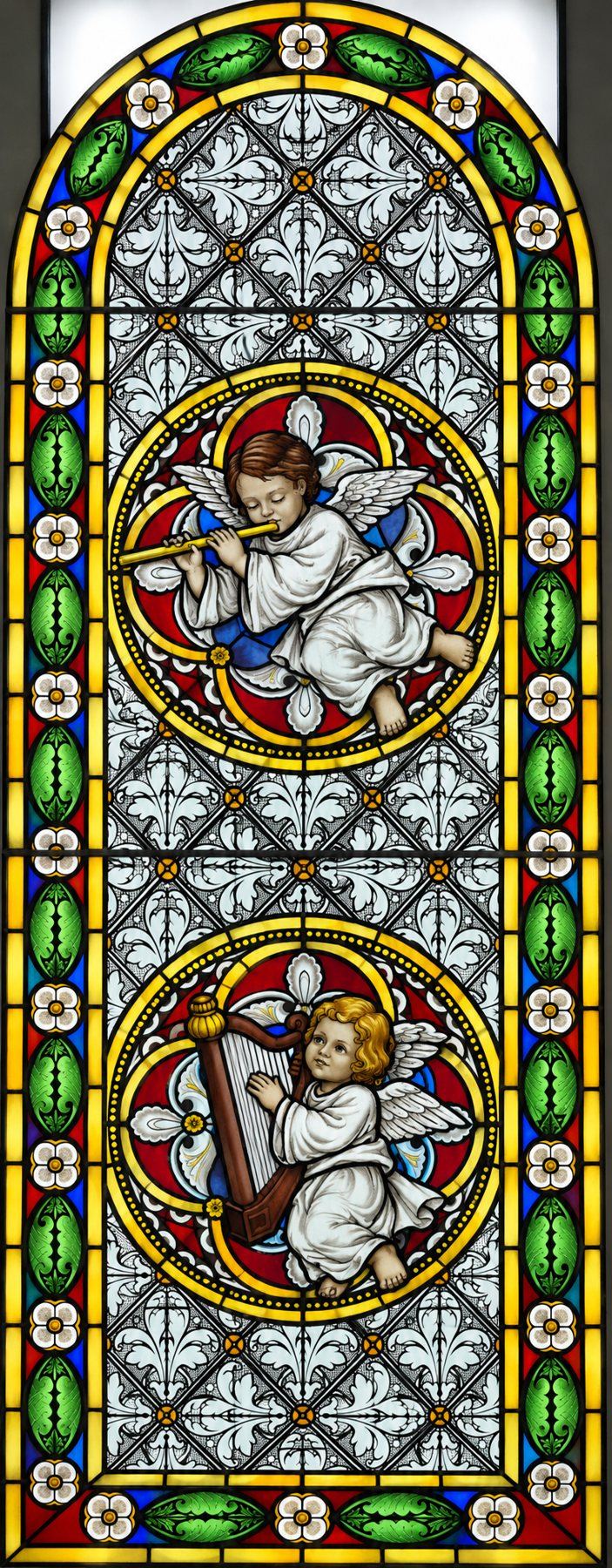 Stained glass window of angels playing the flute and the harp, Stolac